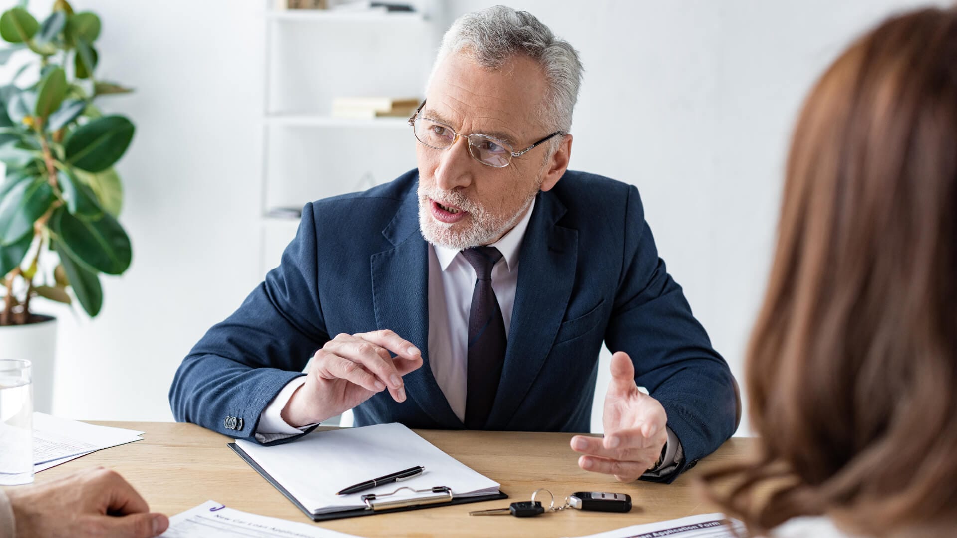 Ein Berater im Consulting-Gespräch mit einem Mann und einer Frau.