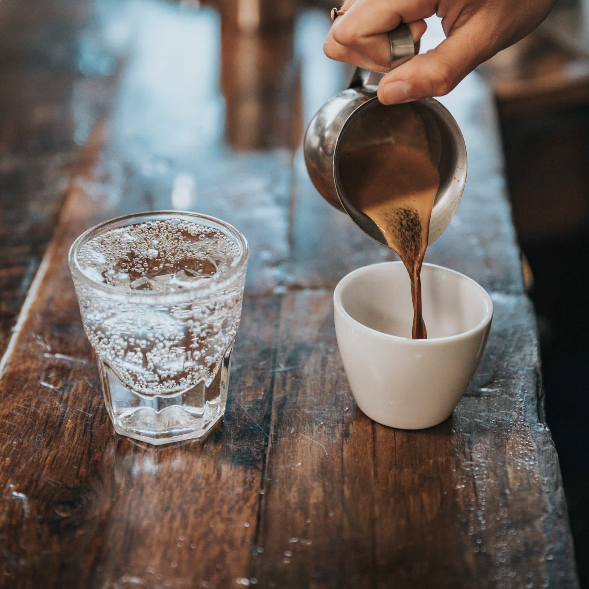 Barista gießt Kaffee in eine Tasse